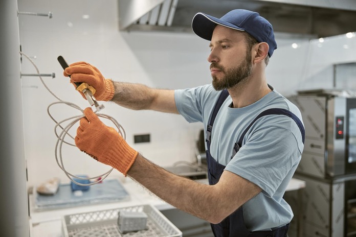Commercial electrician installing power panel
